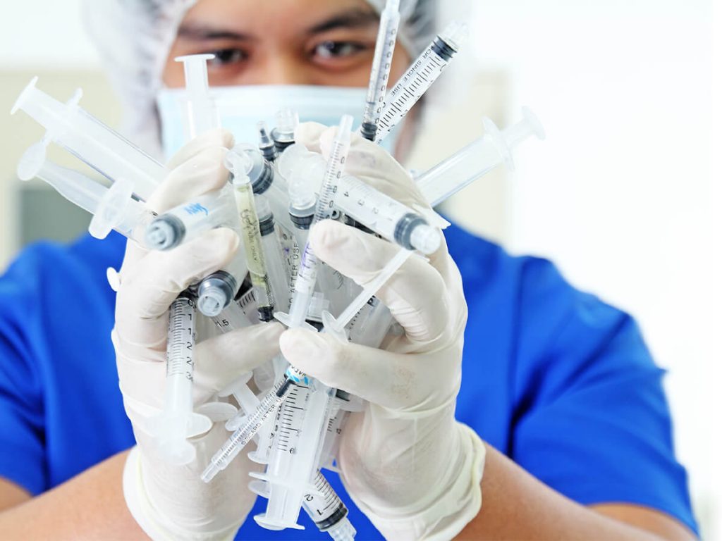 medical professional with handful of medical waste