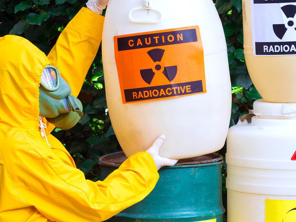 a person in a biohazard suit handling biohazard bins